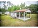 Rustic storage shed in backyard with corrugated metal roof and partially open side, surrounded by grassy yard at 114 Groves St, Walterboro, SC 29488