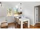 Bright dining area with white table and chairs, hardwood floors, and large windows at 1216 Taliaferro Ave, Charleston, SC 29412