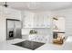 Modern kitchen with white cabinets, quartz countertops, and island with cooktop at 1216 Taliaferro Ave, Charleston, SC 29412