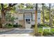 Exterior view of a tan colored building with grey trim, walkway, and landscaping at 162 High Hammock Villas, Seabrook Island, SC 29455