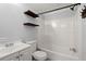 Clean bathroom with a tub, toilet, and wooden shelves at 2002 Valnore Rd, Johns Island, SC 29455