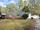 Brick ranch house with red door, landscaped lawn, and a white picket fence at 201 Center St, Walterboro, SC 29488