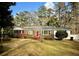 Brick ranch house with red door, landscaped lawn, and a white picket fence at 201 Center St, Walterboro, SC 29488