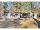 Tan mobile home with covered porch, American flag, and spacious yard at 250 W Medina St, Summerville, SC 29483