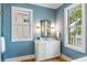 Stylish bathroom with a white vanity, decorative mirror, and natural light from two large windows at 6045 Honey Hole Haven, Johns Island, SC 29455
