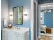Elegant bathroom with a white vanity, decorative mirror, and access to a bedroom at 6045 Honey Hole Haven, Johns Island, SC 29455