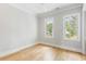 Sunlit bedroom with hardwood floors and two windows offering outdoor views at 6045 Honey Hole Haven, Johns Island, SC 29455