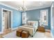 Comfortable bedroom featuring hardwood floors, soft blue walls, and natural light from two large windows at 6045 Honey Hole Haven, Johns Island, SC 29455