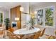 Dining area featuring a large white table, wicker chairs, modern lighting, and large windows providing ample natural light at 6045 Honey Hole Haven, Johns Island, SC 29455