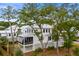 Charming white home with a screened-in porch, surrounded by mature trees and landscaping at 6045 Honey Hole Haven, Johns Island, SC 29455