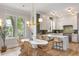 Open concept kitchen with white cabinetry, stainless appliances, marble countertops, and an adjacent dining area flooded with natural light at 6045 Honey Hole Haven, Johns Island, SC 29455