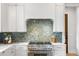 Close up of modern kitchen design featuring white cabinetry, stainless steel appliances, and a stylish tile backsplash at 6045 Honey Hole Haven, Johns Island, SC 29455