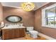 Charming powder room with a stylish vanity, decorative mirror, and unique light fixture at 6045 Honey Hole Haven, Johns Island, SC 29455