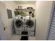 Small laundry room with washer, dryer, and storage shelving at 61 Twin Oaks Ln, Isle of Palms, SC 29451
