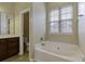 Bathroom with a bathtub, toilet and wooden vanity at 7315 Coopers Hawk Dr, Hanahan, SC 29410