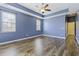 Large bedroom with blue walls, hardwood floors, and ceiling fan at 7315 Coopers Hawk Dr, Hanahan, SC 29410