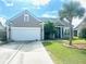 Beige house with white garage door, landscaping, and palm trees at 7315 Coopers Hawk Dr, Hanahan, SC 29410