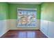 Empty bedroom with wood flooring, green walls, and white wainscoting at 8419 Creekstone Ct, North Charleston, SC 29406