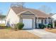 Tan house with brown roof, white garage door, and small front porch at 8419 Creekstone Ct, North Charleston, SC 29406