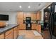 Modern kitchen with light wood cabinets, black appliances, and an island at 9632 Scarborough Ct, Summerville, SC 29485