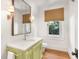 Light and airy powder room with a green vanity and white countertop at 119 Halona Ln, Kiawah Island, SC 29455