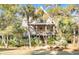Two-story home with a charming front porch and lush landscaping at 119 Halona Ln, Kiawah Island, SC 29455