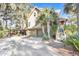 Home with two-car garage and elevated deck, surrounded by trees at 119 Halona Ln, Kiawah Island, SC 29455