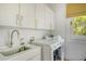 Bright laundry room with white cabinets and a large window at 119 Halona Ln, Kiawah Island, SC 29455