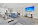 Bright living room features comfy sofas, a large TV, and hardwood floors at 119 Leeward Lndg, Summerville, SC 29486
