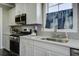 White kitchen with stainless steel appliances and gray backsplash at 1209 Hammrick Ln, Johns Island, SC 29455