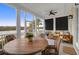 Relaxing screened porch overlooking waterfront with wooden furniture at 1583 Paradise Lake Dr, Mount Pleasant, SC 29464