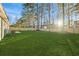 Large backyard with a fenced-in lawn, patio, and mature trees at 444 Longleaf Dr, Summerville, SC 29483