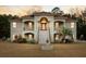Two-story house with stucco siding, red tile roof, and a fountain in the front yard at 4712 Westervelt Rd, Meggett, SC 29449