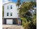 Two-story white house with colorful stairs and garage at 79 Sandbar Ln, Folly Beach, SC 29439