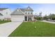Two-story house with gray siding, white garage door, and a well-manicured lawn at 8700 Forte Dr, North Charleston, SC 29406