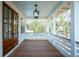 Inviting porch with wood floors, white railings and posts, and a lantern light fixture at 9005 Stern Aly, Johns Island, SC 29455