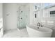 A stylish bathroom features a glass shower, freestanding tub, and elegant marble tile flooring at 9009 Stern Aly, Johns Island, SC 29455