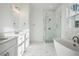 Bright bathroom with double sinks, a glass shower, and a freestanding bathtub at 9009 Stern Aly, Johns Island, SC 29455