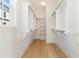 Bright walk-in closet with wooden floors, built-in shelves, and hanging rods for clothes at 9009 Stern Aly, Johns Island, SC 29455