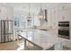 Bright kitchen features stainless appliances, white cabinetry, and large island with marble countertop at 9009 Stern Aly, Johns Island, SC 29455