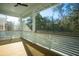 Screened porch with natural wood floors and a picturesque view of the surrounding trees at 9009 Stern Aly, Johns Island, SC 29455