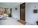 Bright porch with wooden door, a wreath, and cozy seating area at 11 Perry St, Charleston, SC 29403
