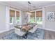 Bright dining room features a rustic wood table, white chairs, and large windows at 270 Darby Meadow Ln, Ridgeville, SC 29472