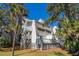 White two-story building with decks and lush landscaping at 279 Driftwood Ln, Edisto Beach, SC 29438
