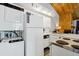 White kitchen features stacked washer/dryer, stove, refrigerator, and ample counter space at 279 Driftwood Ln, Edisto Beach, SC 29438