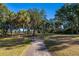 Paved walking path through lush, tree-lined landscape at 279 Driftwood Ln, Edisto Beach, SC 29438