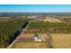 Aerial view of house with pool and large yard surrounded by trees and farmland at 534 Farmers Market Rd, Saint George, SC 29477