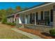 Front porch with blue door, wooden bench, and plants at 534 Farmers Market Rd, Saint George, SC 29477