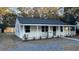 Charming white cottage with a front porch and well-maintained landscaping at 5614 Read St, North Charleston, SC 29406