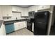 Modern kitchen featuring white cabinets, black appliances, and a teal dishwasher at 5614 Read St, North Charleston, SC 29406